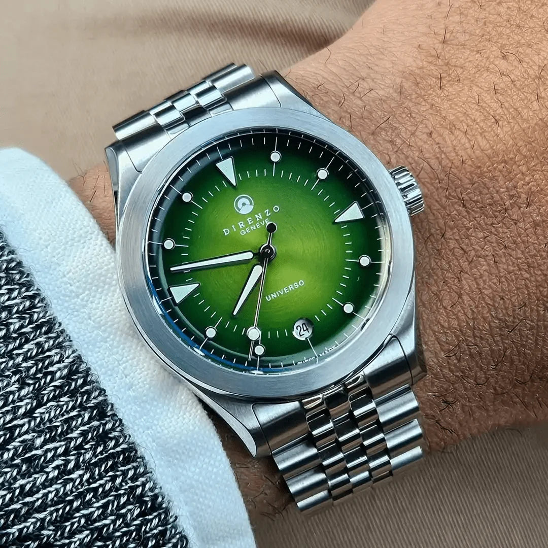 Silver watch with a green face on a wrist, brand 'Dipenzio' visible