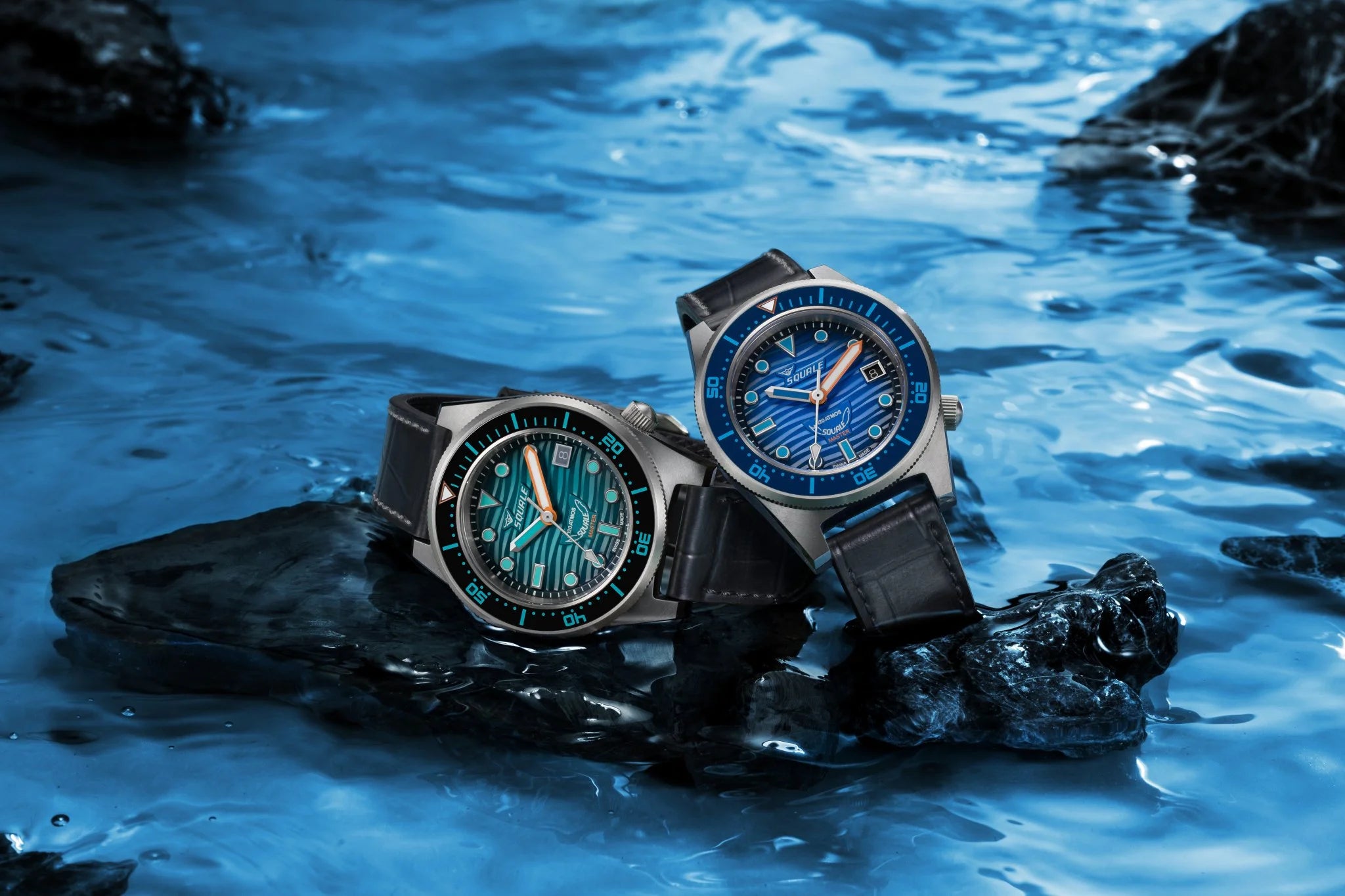 Two watches on a rock with water in the background