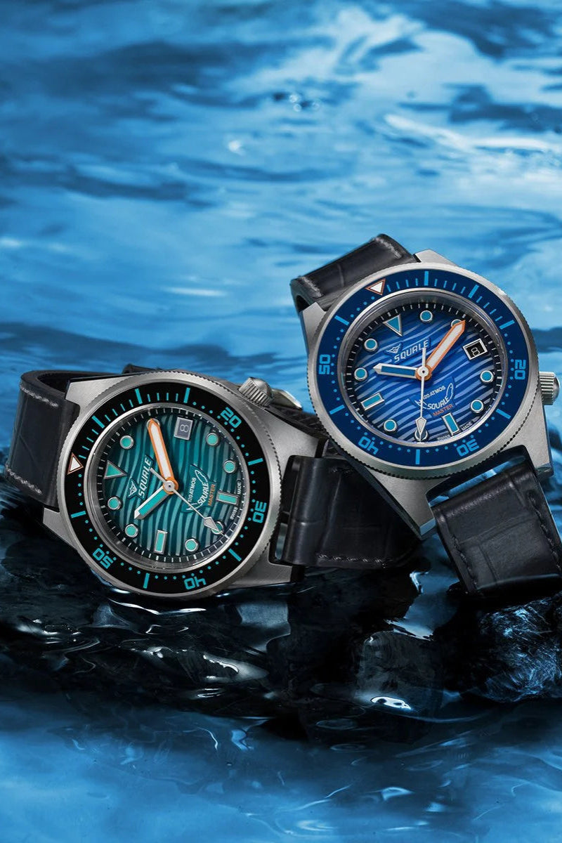 Two watches with blue and green faces on a water background
