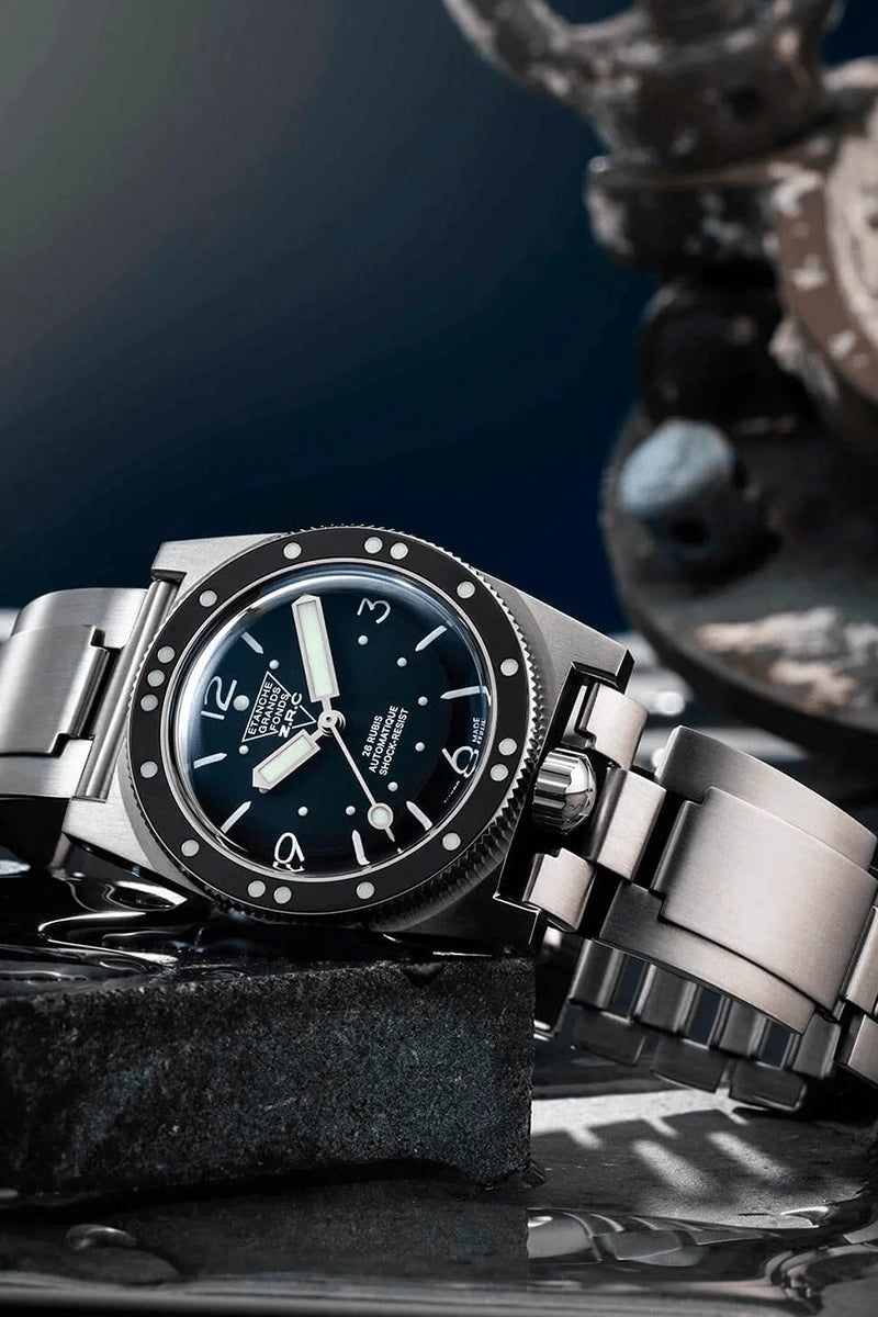 Silver watch with a dark face on a textured surface